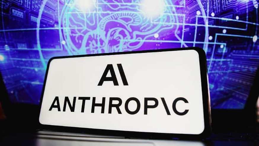 ป้ายโลโก้ Anthropic AI ตั้งอยู่หน้าจอแสดงกราฟิกเครือข่ายวงจรดิจิทัล