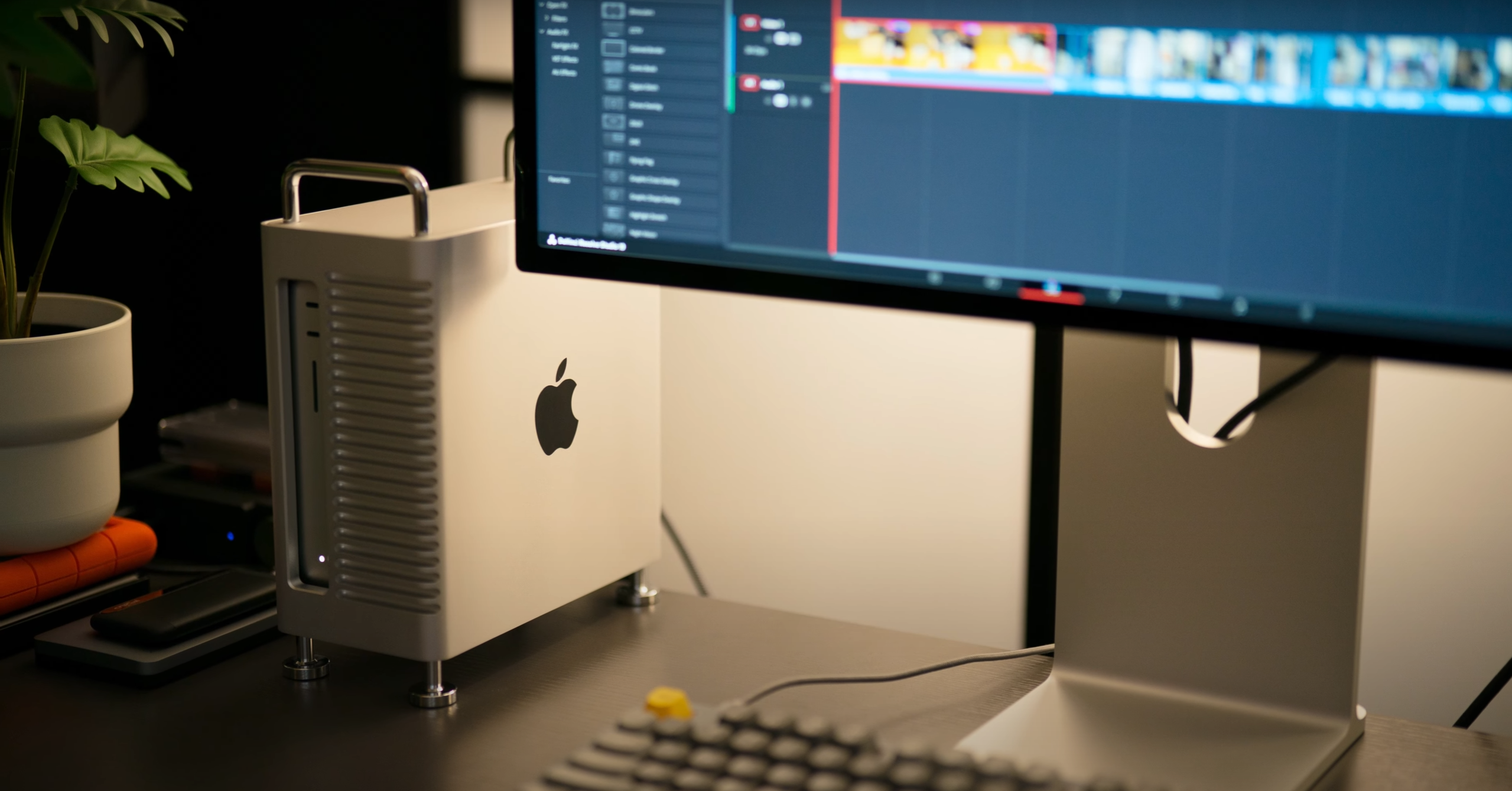 เครื่อง Apple Silicon วางอยู่บนโต๊ะทำงานข้างจอภาพที่เปิดซอฟต์แวร์ตัดต่อวิดีโอ