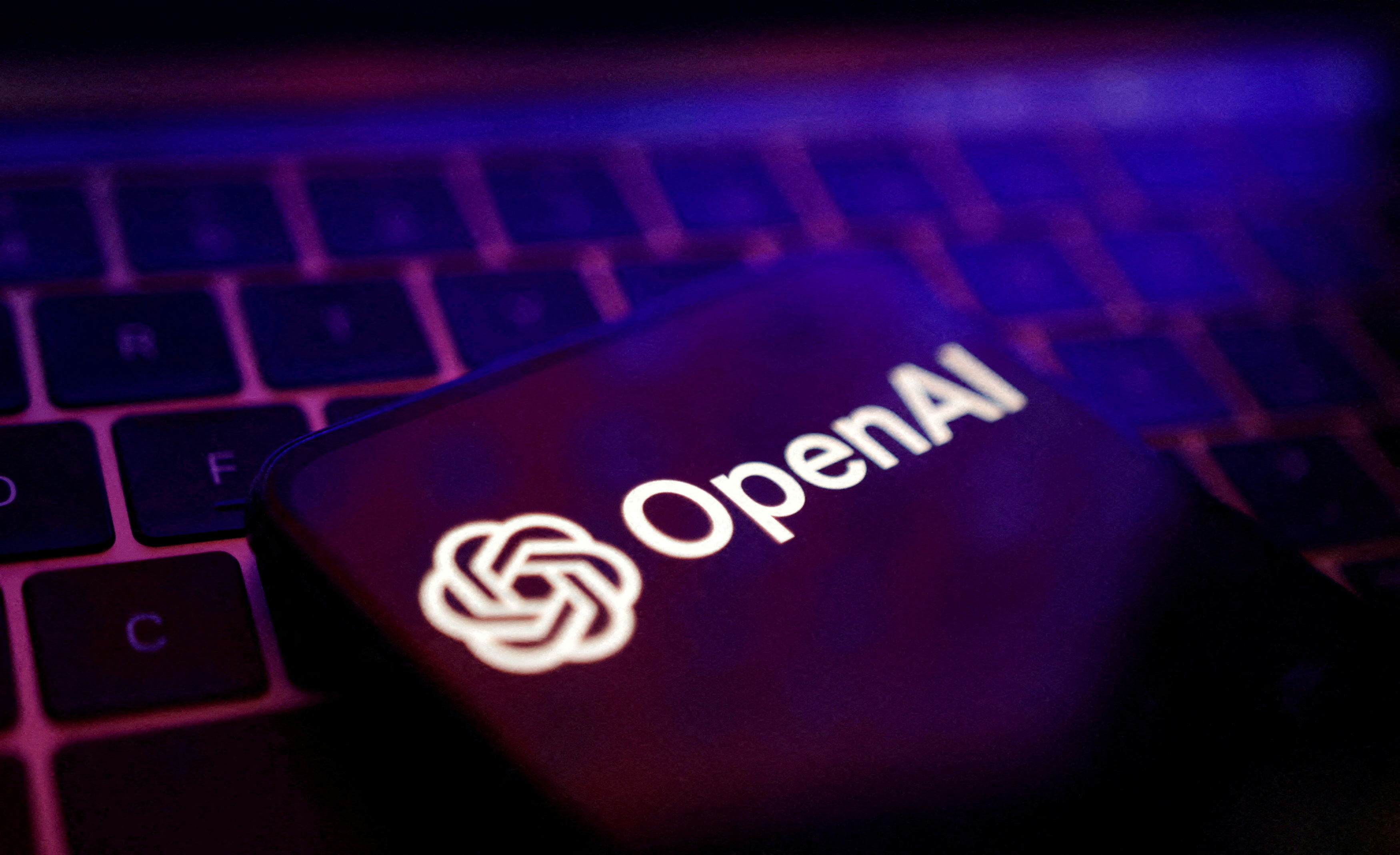 โลโก้ OpenAI ปรากฏบนหน้าจอที่วางอยู่บนแป้นพิมพ์แล็ปท็อป สื่อถึงประเด็นข้อมูลที่เชื่อมโยงระหว่าง Apple และ OpenAI ในคดีนี้