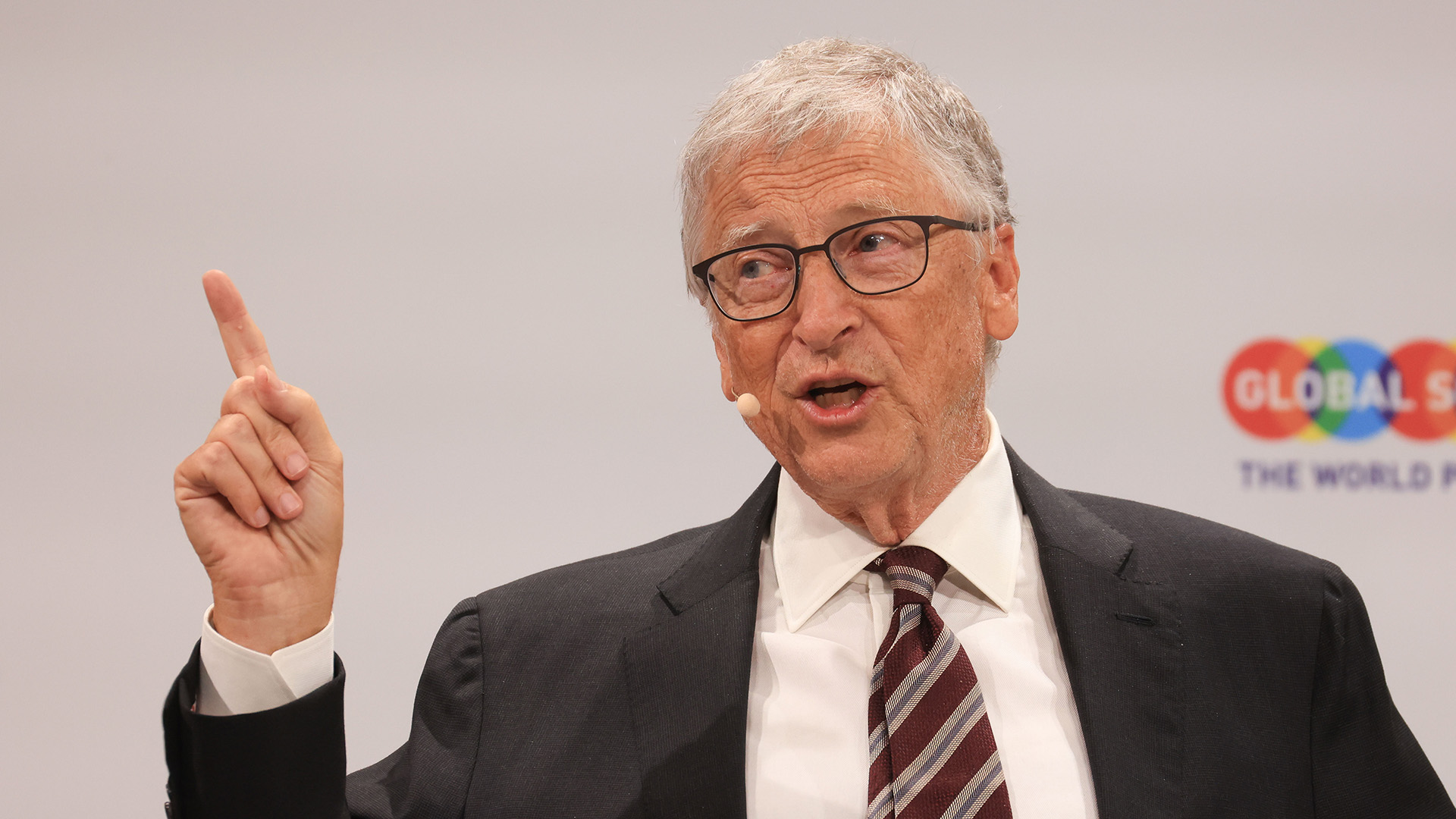 Bill Gates พูดและชี้นิ้วระหว่างขึ้นเวทีงานประชุม