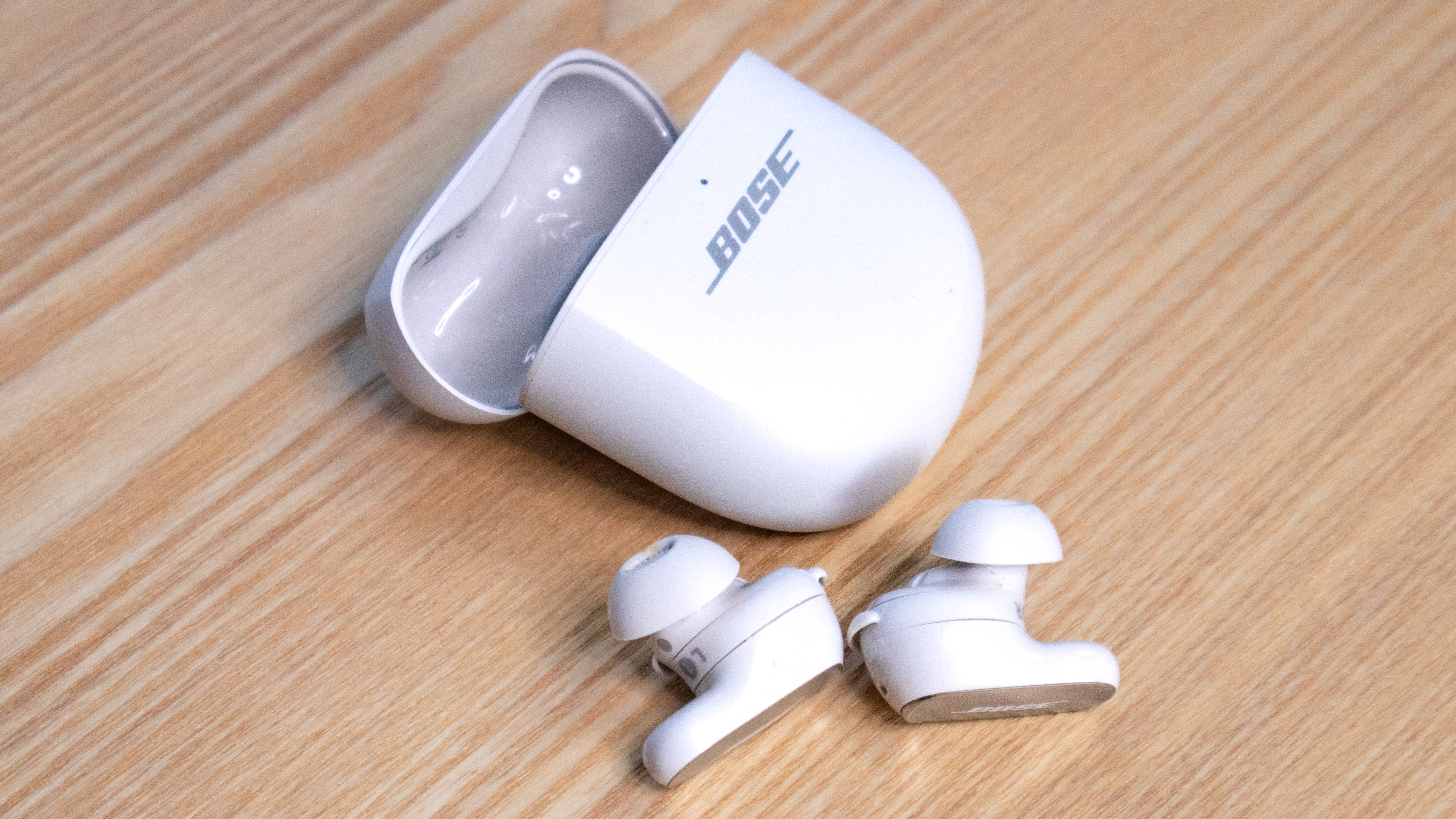 หูฟัง Bose พร้อมเคสวางอยู่บนพื้นผิวไม้