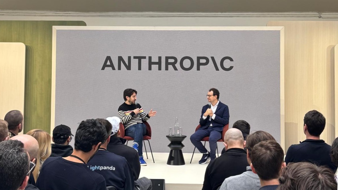ผู้บริหาร Anthropic ร่วมพูดคุยบนเวทีหน้าโลโก้บริษัท สะท้อนบริบทที่ Dario Amodei เขียนถึงการ pace the frontier