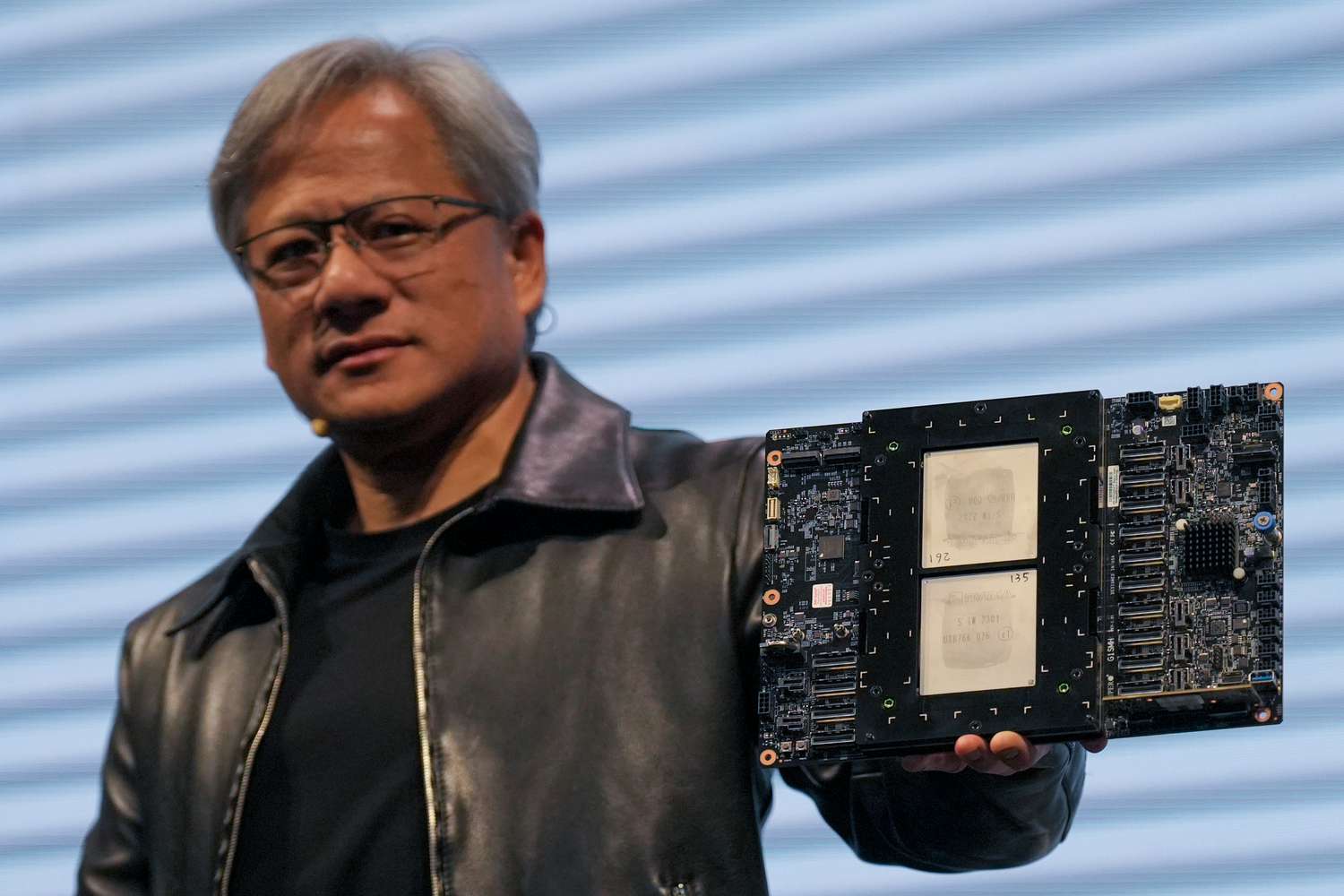 Jensen Huang ซีอีโอ Nvidia ถือแผงชิปบนเวที สะท้อนความเชื่อมโยงระหว่าง Nvidia กับดีลที่ดึงทีมงานหลักของ Groq ไปร่วมงาน