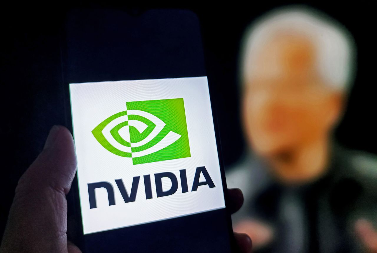 โลโก้ Nvidia บนหน้าจอสมาร์ตโฟน กับภาพเบลอของผู้บริหารด้านหลัง