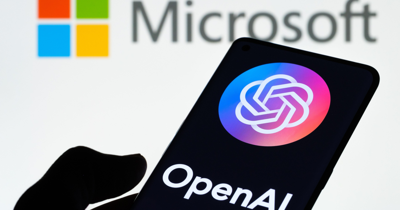 โลโก้ Microsoft และ OpenAI บนหน้าจอสมาร์ตโฟน สื่อถึงความสัมพันธ์ระหว่างสองบริษัทในธุรกิจ AI