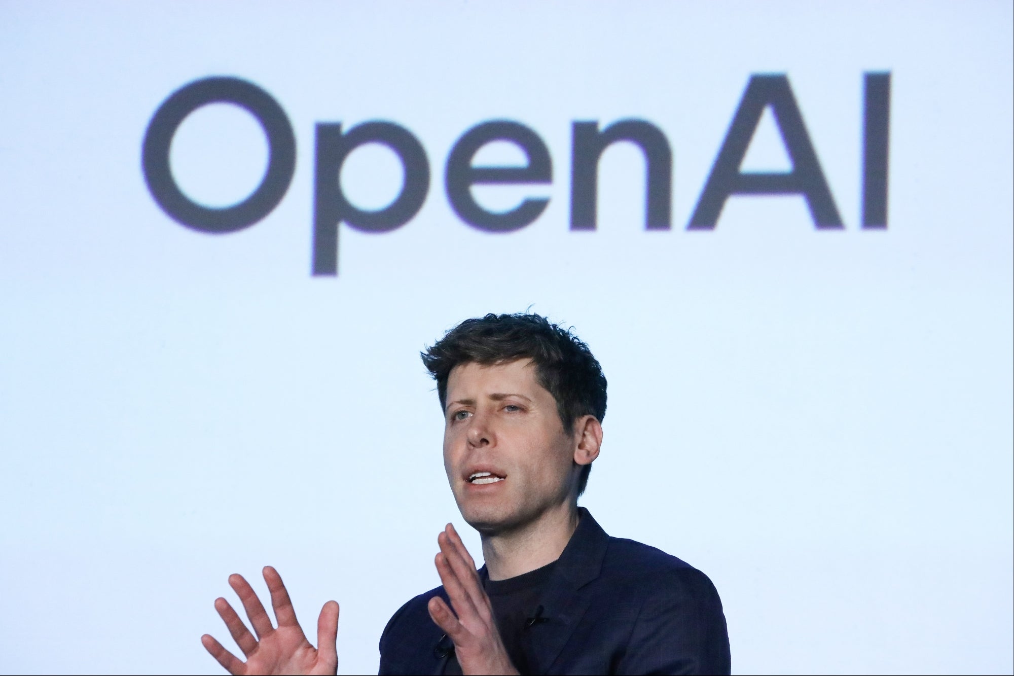 ภาพโลโก้ OpenAI บนเวทีกิจกรรมของบริษัท